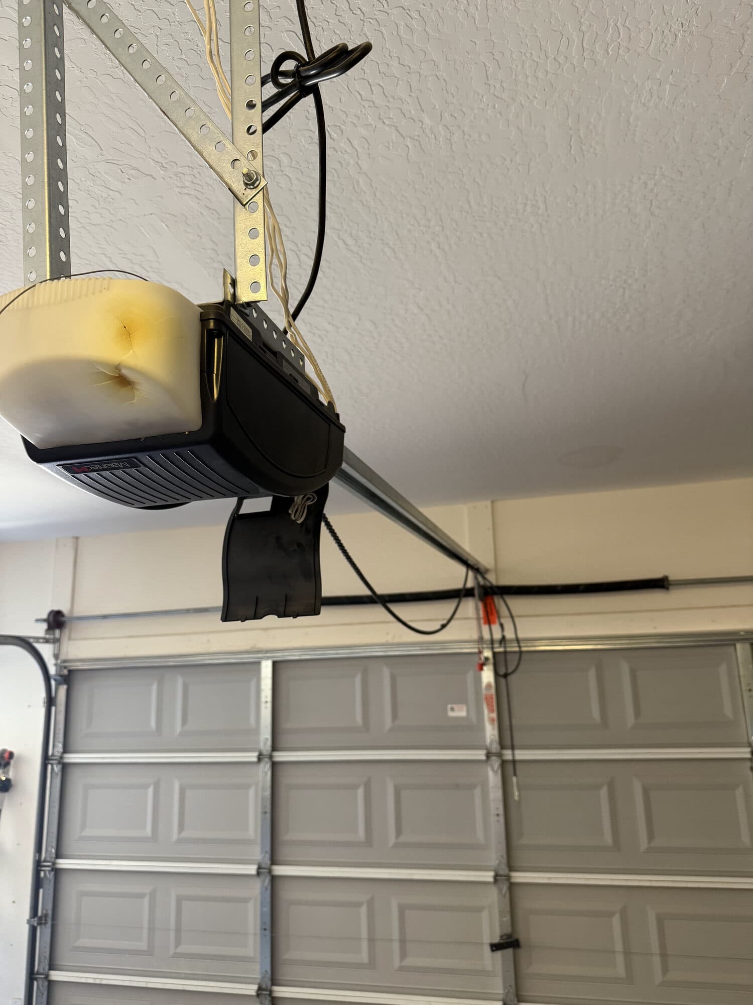 One of two 30-year-old garage door opener motors, yellowed with age, before replacement in Peoria, AZ