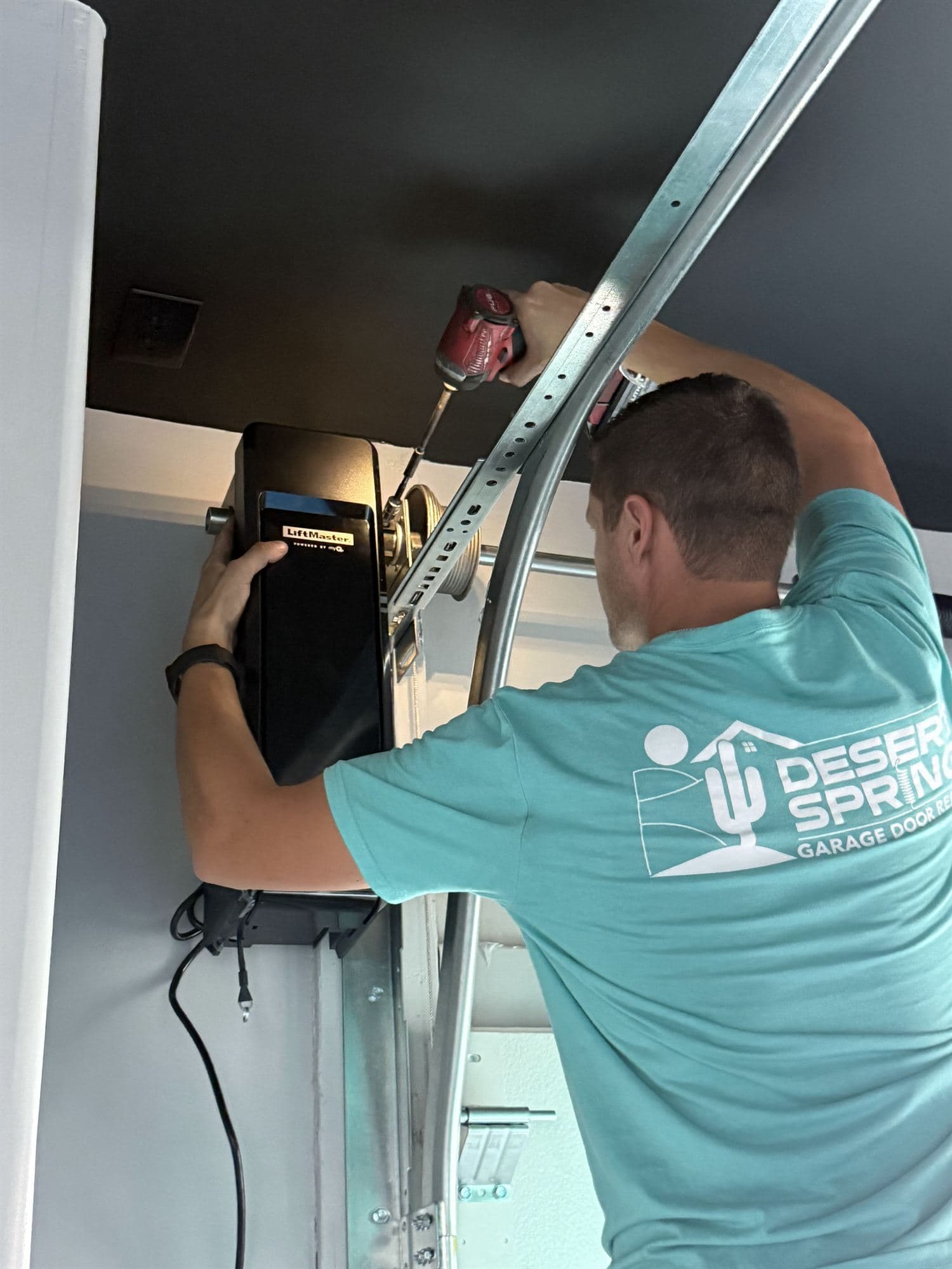 Garage Door Opener Installation Phoenix Desert Spring technicians mounting a garage door opener in a Phoenix, AZ garage
