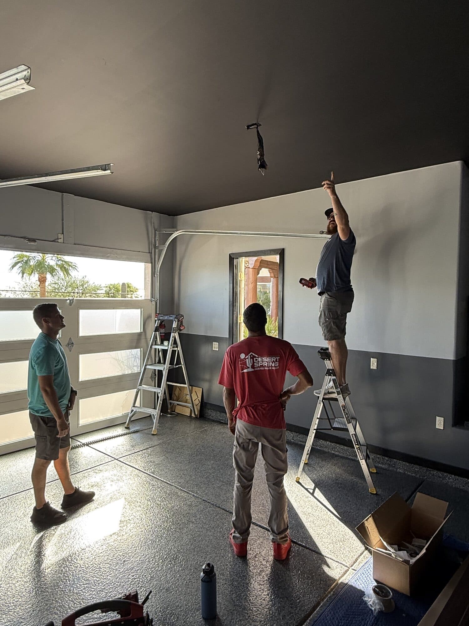 Garage Door Repair Phoenix Desert Spring crew installing new glass garage doors in a Phoenix, AZ garage